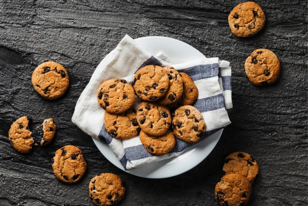  A close-up of a pile of mini chocolate chip cookies, showcasing their perfect bite-size and rich chocolate chips.