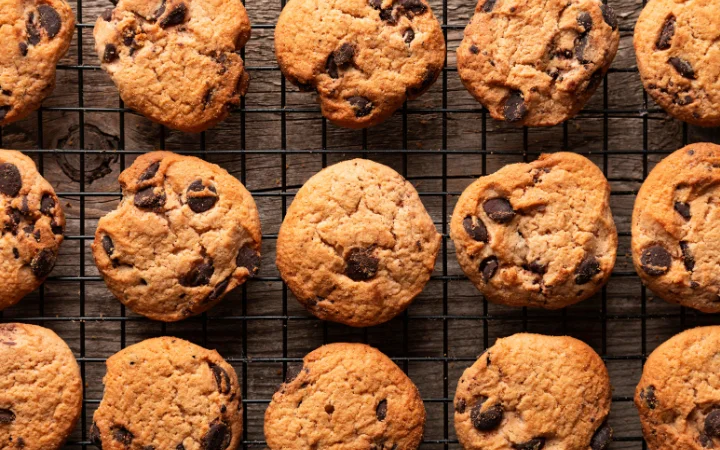 An organized display of cookies made with different brands of chocolate chips, each labeled for comparison. The image highlights the texture and melting characteristics of the chocolate chips from brands like Trader Joe's and Scharffen Berger.