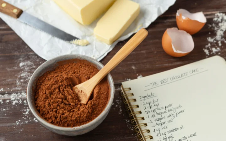 neatly arranged set of ingredients for chocolate pound cake, including room-temperature butter, eggs, cream cheese, cake flour, and Dutch-processed cocoa.