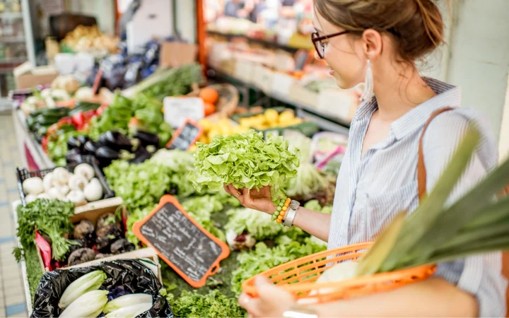 A farmer's market scene with baskets of fresh, seasonal vegetables like root veggies for winter and zucchini for summer.