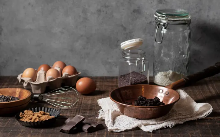  Ingredients for mini chocolate chip cookies (flour, sugar, butter, eggs, chocolate chips) neatly arranged on a kitchen counter.