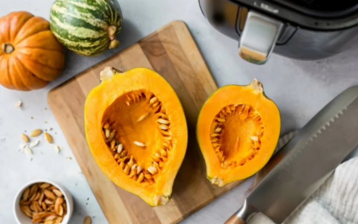 preparing butternut squash for air frying, washing, cutting, scooping seeds, cubing, kitchen scene with knife and air fryer basket