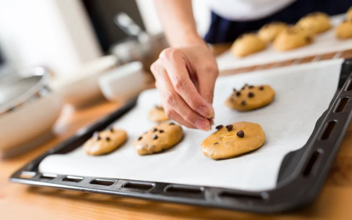 A baker skillfully using Ghirardelli chocolate chips in baking, demonstrating best practices and techniques.