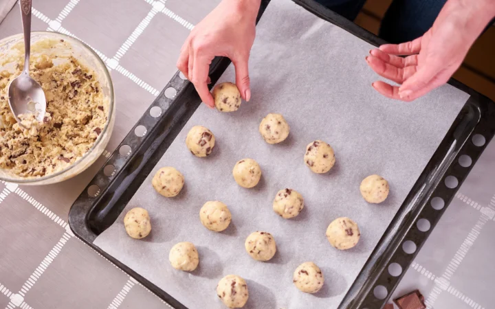 An organized display of cookies made with different brands of chocolate chips, each labeled for comparison. The image highlights the texture and melting characteristics of the chocolate chips from brands like Trader Joe's and Scharffen Berger.