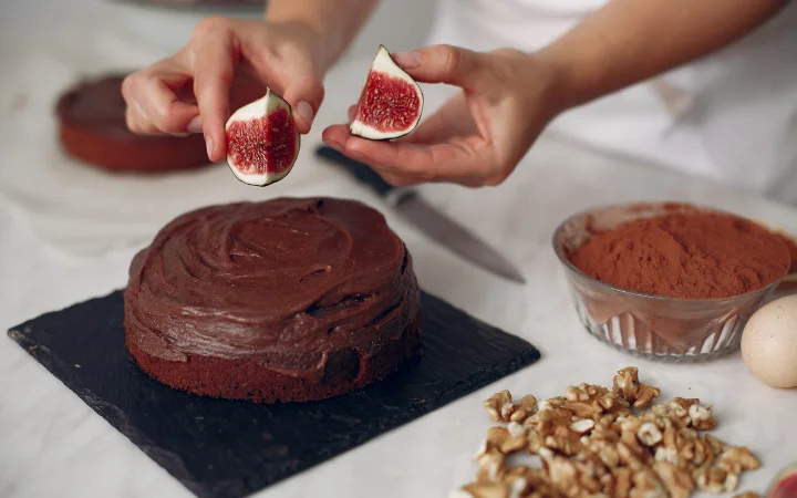 A beautifully decorated chocolate coffee cake with chocolate buttercream frosting and elegant garnishes.