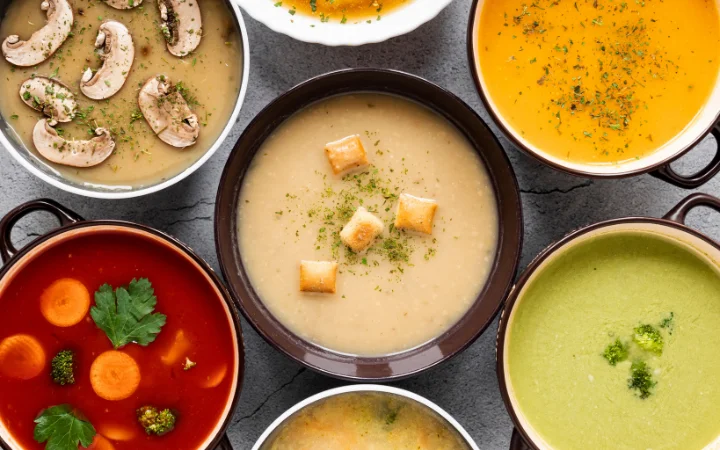 serving chiken gnouchi soup on a dinning table with other meals