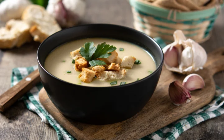 A beautifully laid dining table showcasing Chicken Gnocchi Soup served with recommended pairings – crusty bread, a light salad, steamed vegetables, and a selection of wines and non-alcoholic beverages, creating an inviting dining experience.