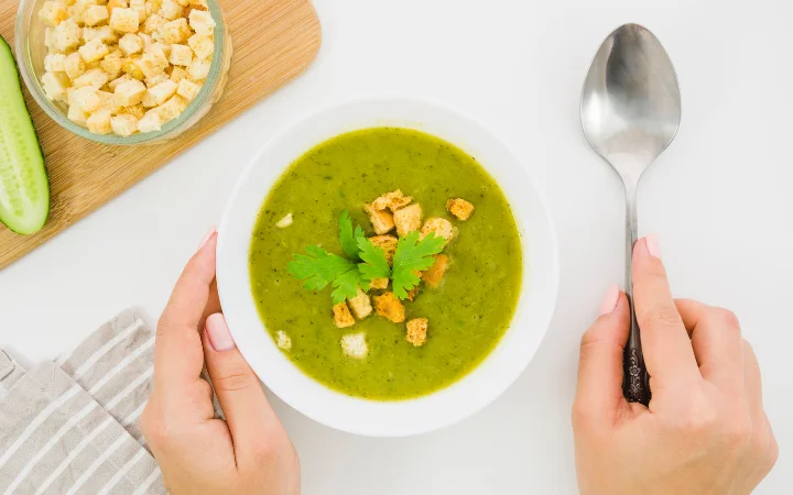 A heartwarming scene of a women enjoying broccoli cheddar soup in a homely kitchen, emphasizing the cake's role in bringing people together.