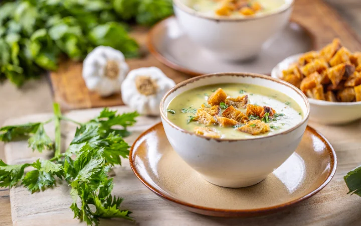 A cozy dining room where a family enjoys bowls of Chicken Gnocchi Soup, with a FAQ board in the background addressing common questions, symbolizing a satisfying conclusion to the soup-making journey.