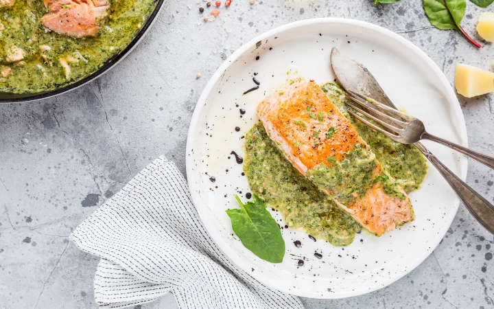 A joyful home cooking scene with a family gathered around a table enjoying a meal of chimichurri salmon.