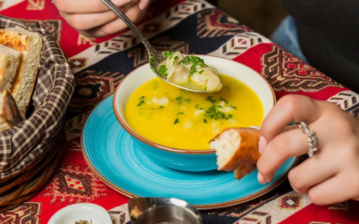 A warm and inviting kitchen scene where a finished pot of gnocchi soup sits on a rustic table