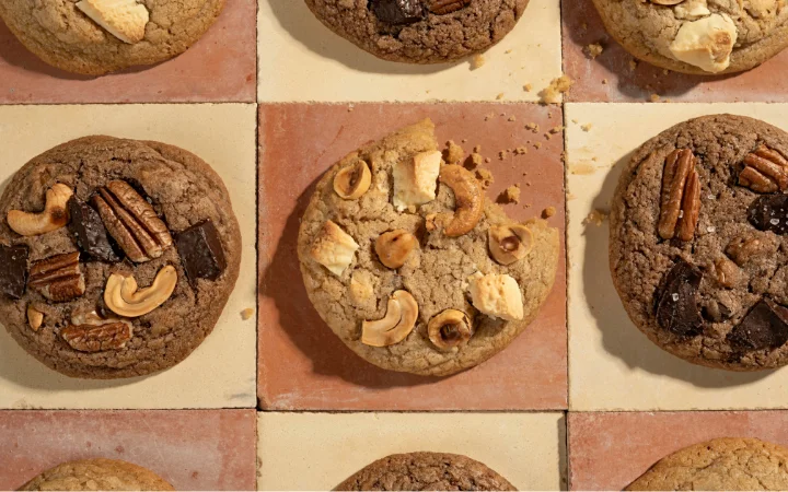 A creative display of various chocolate chip cookie variations, including cookies with nuts, spices, and different chocolate chip types. The image is colorful and inviting, highlighting the endless possibilities in cookie baking.