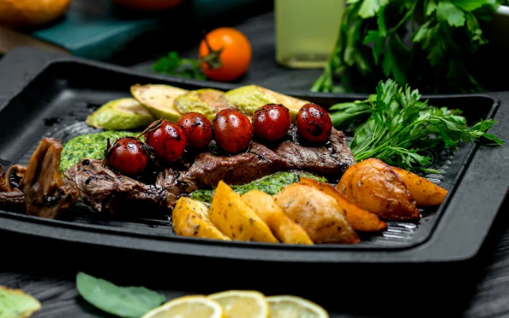 A gourmet presentation of braised corned beef brisket with roasted vegetables and a rich sauce, served on an elegant plate.