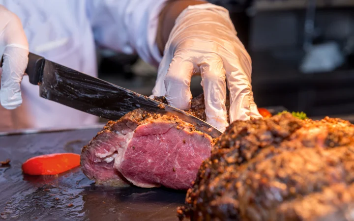 A perfectly cooked corned beef being seared in a hot cast iron skillet, achieving a golden-brown crust, enhancing its flavor and texture.