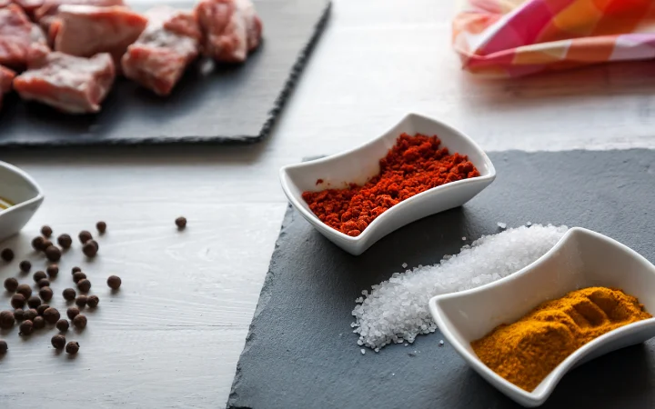 A creative kitchen setting where spices are being used in various dishes, such as stews and roasted vegetables.