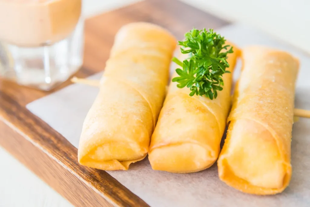  A vibrant kitchen scene showcasing the fusion of egg rolls, with ingredients like corned beef and egg roll wrappers artistically displayed.