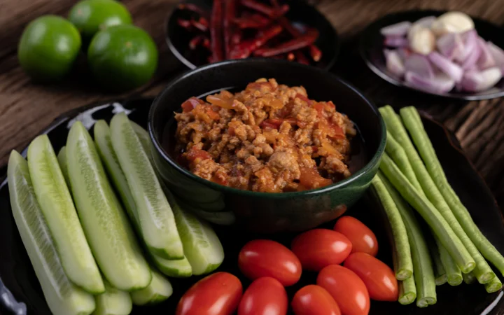 A balanced meal plate featuring Filipino corned beef with a side of vegetables, accompanied by an informative nutritional chart highlighting protein, sodium, and vitamin content.