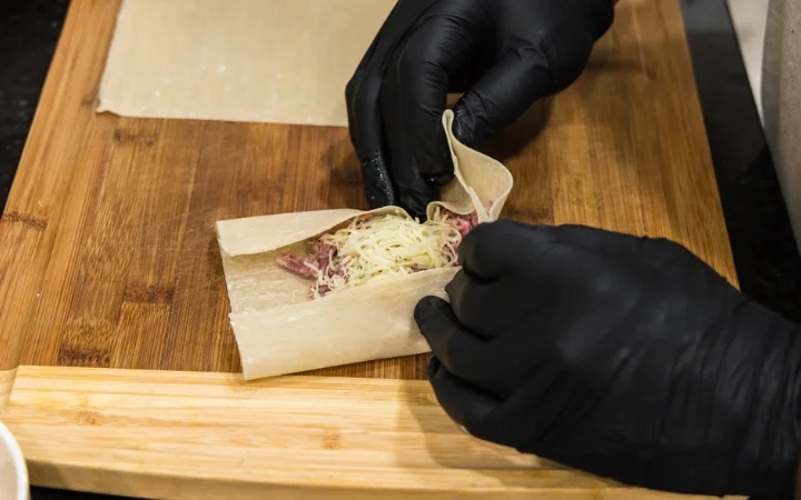 A kitchen scene with a chef demonstrating the art of making perfect egg rolls, showing common mistakes and how to avoid them.