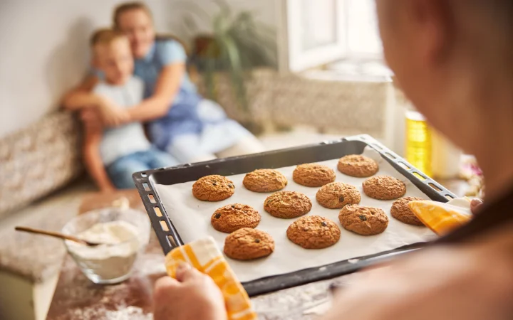 A heartwarming scene of a family enjoying Cowboy Cookies together in a home kitchen, with a tray of cookies in the center, symbolizing the joy of baking and sharing.