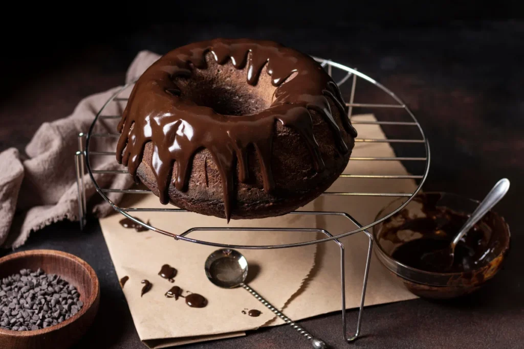 A classic chocolate pound cake on a vintage wooden table, with a rich, dark chocolate glaze dripping down the sides.