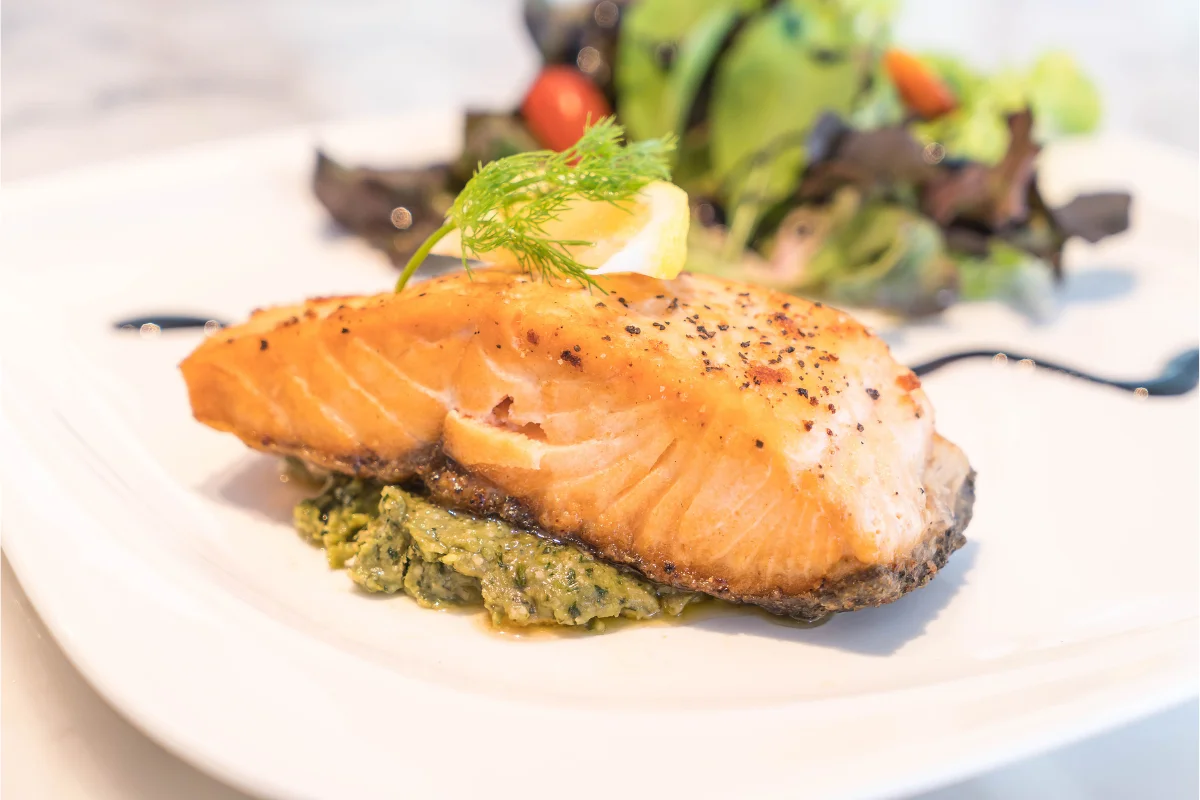 A beautifully plated dish of chimichurri salmon, showcasing the vibrant green sauce over a perfectly cooked salmon fillet.