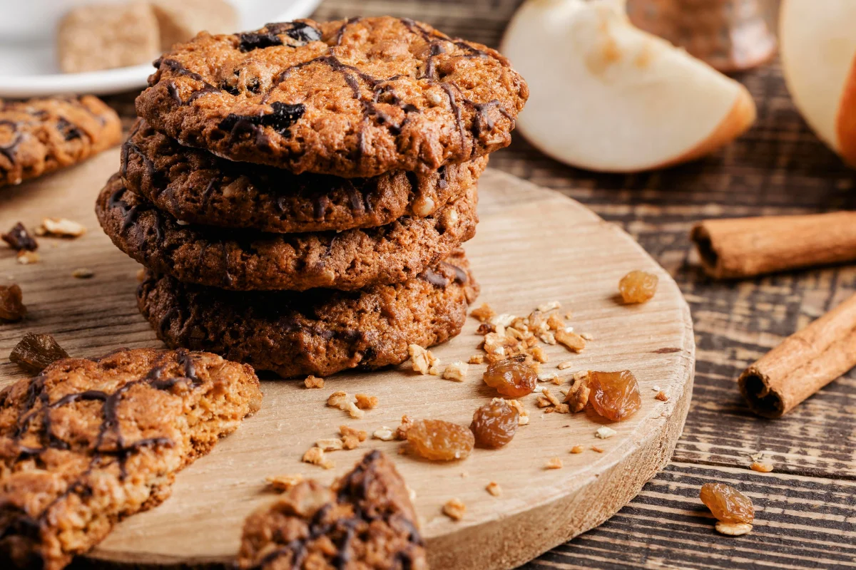 A cozy kitchen scene with a batch of freshly baked Cowboy Cookies on a rustic wooden table. The background shows a framed photo of Laura Bush and a small American flag, highlighting the origin of the recipe.