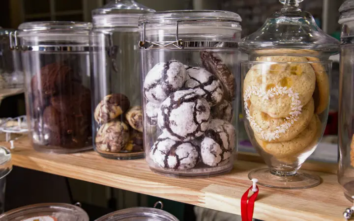 Nostalgic image capturing the essence of chocolate chip cookies through the years, with modern and vintage cookie jars side by side, creating a warm and inviting atmosphere.