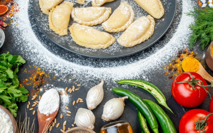 A vibrant display of freshly made pasta on a wooden table, surrounded by colorful Venezuelan decorations.