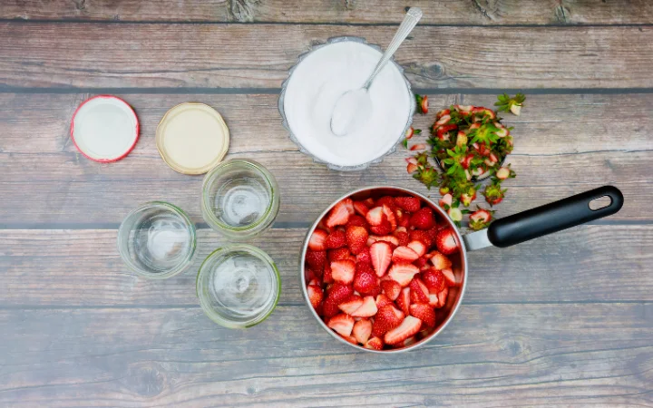 To make jam fresh strawberries are cleaned and cut into pieces