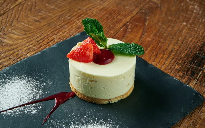 an elegant dessert beautifully decorated with powdered sugar, fresh berries, menth.