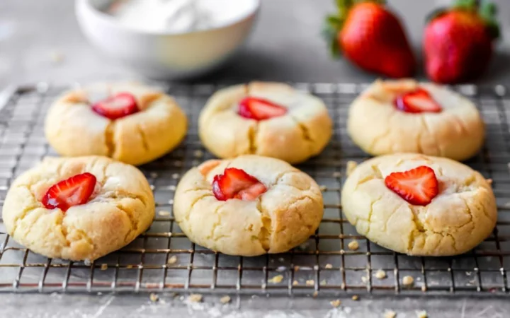 A warm, inviting image of cookies fresh out of the oven, sitting on a baking sheet with golden-brown edges. A wire rack is seen in the background, ready for the cookies to be transferred for cooling, highlighting the anticipation of the final product.