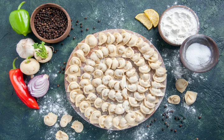 Top view little raw dumplings with flour on dark gray background dough color food food dish meat calorie meal