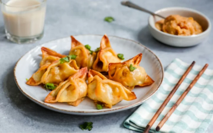 kitchen scene of baked crab rangoon plaate on side of the plate, light background