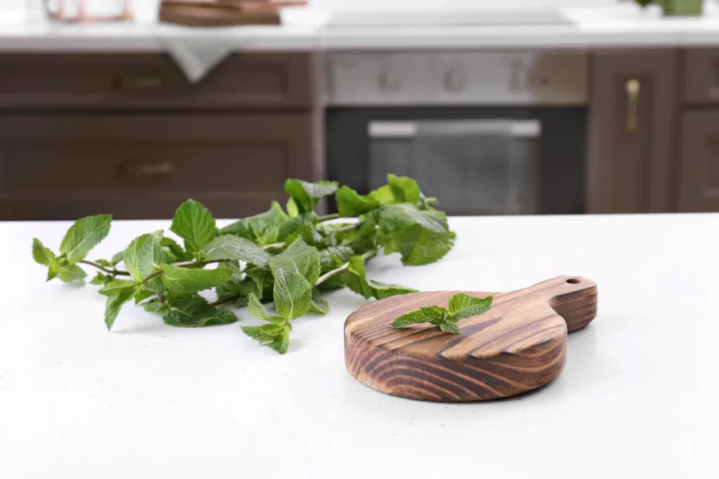 Wooden board on table in kitchen with peppermint.