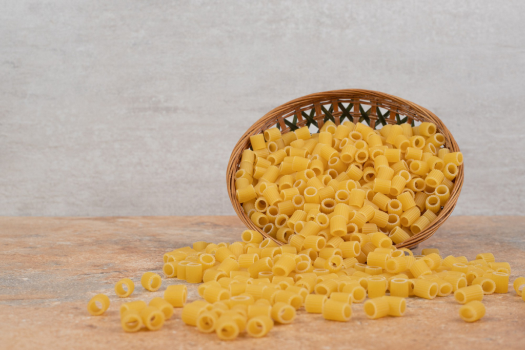 Heap of raw ditalini pasta on wooden basket. high quality photo